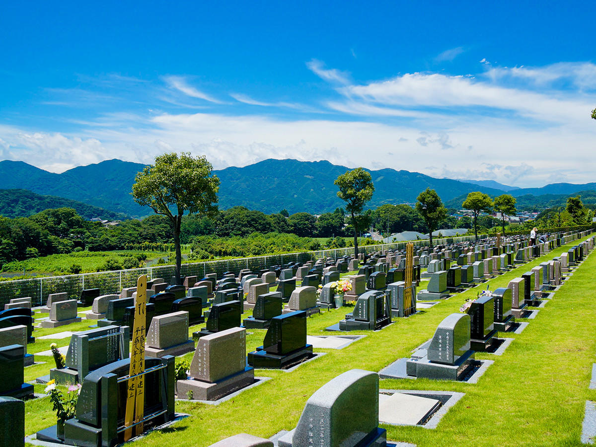 丹沢の山並み、大きな空の下美しい緑の芝生の中に洋型の墓石が整然と並んでおります。